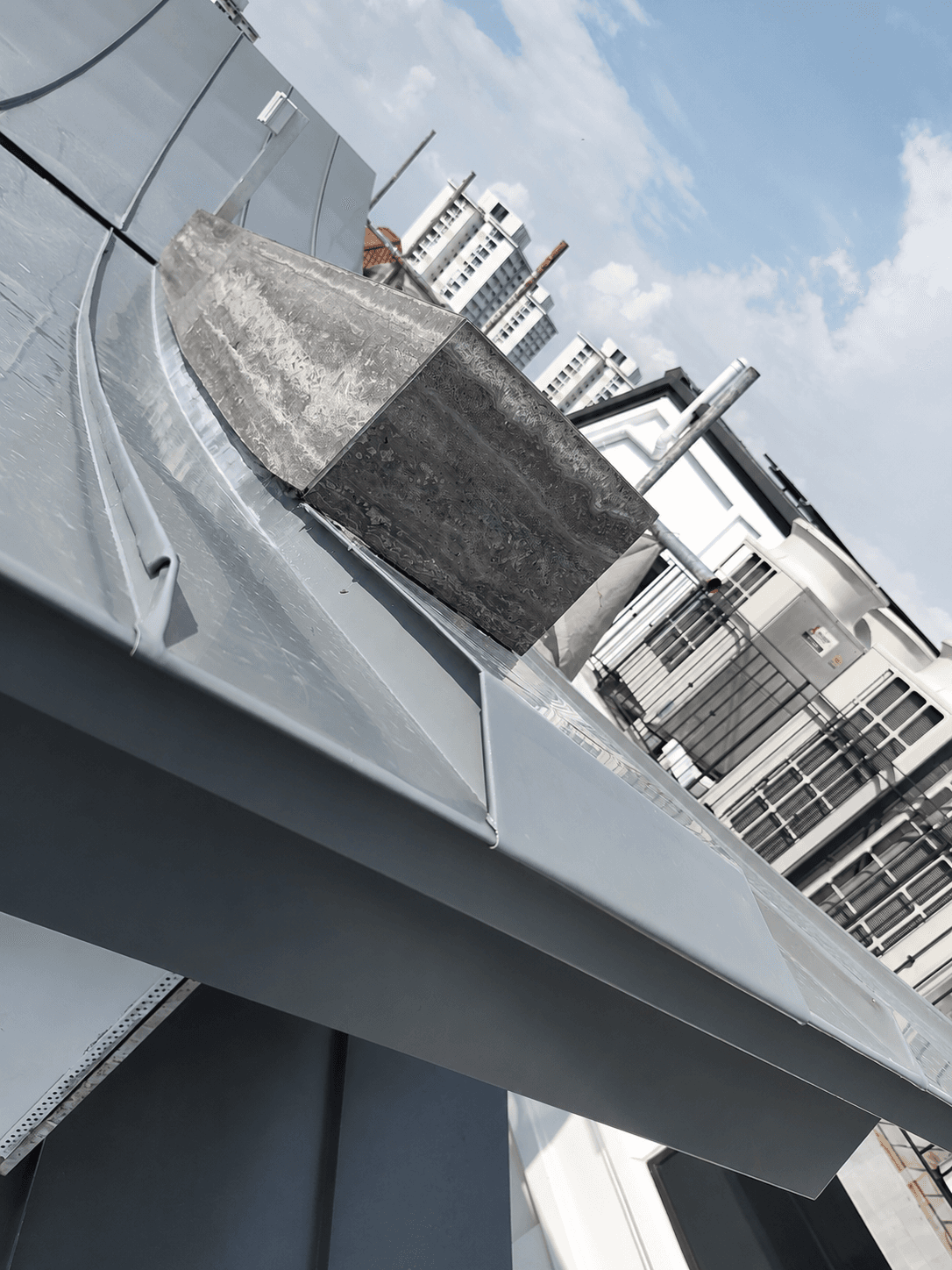 Close view of folded metal flashing around a roof junction