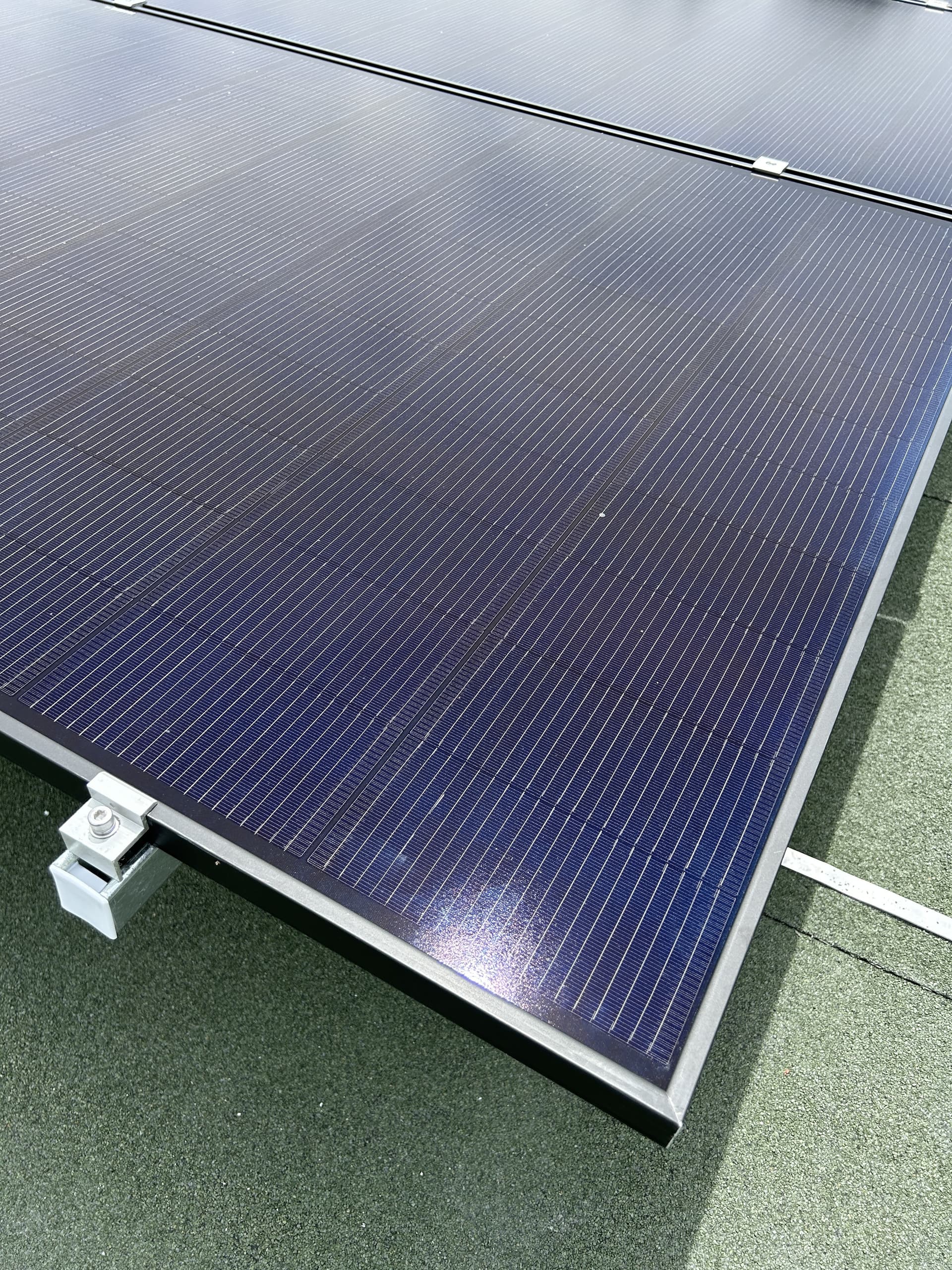 Water drainage clip installed along the edge of a solar panel